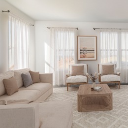 Spacious and well-lit living spaces room with couch chair and large windows