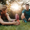 woman and man stretching in the grass