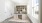 a room with white walls and a counter with a cabinet and a door with a plant